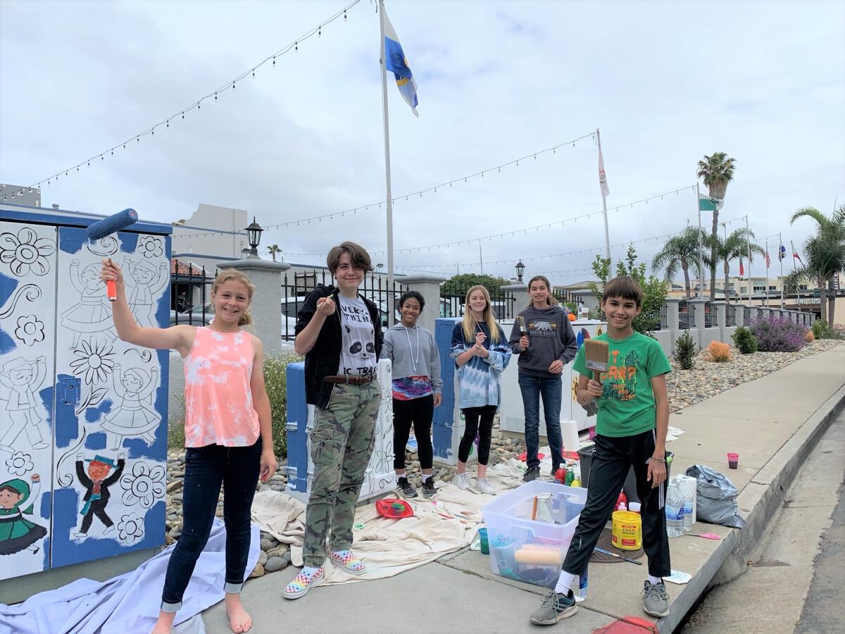Students from Warren-Walker School get ready to paint designs on utility boxes outside the Portuguese Hall in Point Loma.