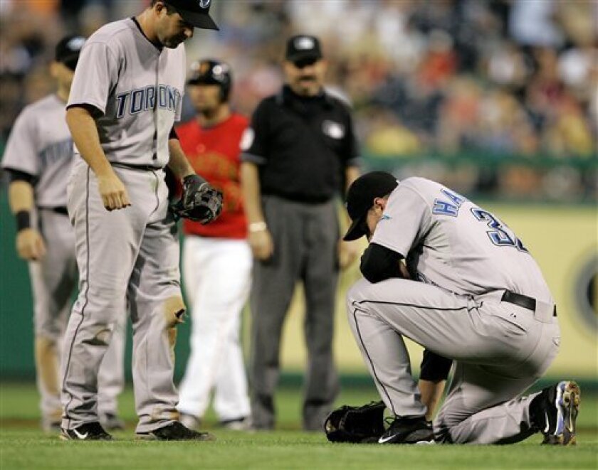 Toronto Blue Jays pitcher Roy Halladay, right, reacts after being hit by a seventh-inning line drive up-the-middle by Pittsburgh Pirates' Nyjer Morgan in a baseball game at Pittsburgh, Friday, June 20, 2008. Halladay walked off the field and left the game. At left is Blue Jays shortstop John McDonald. (AP Photo/Gene J. Puskar)