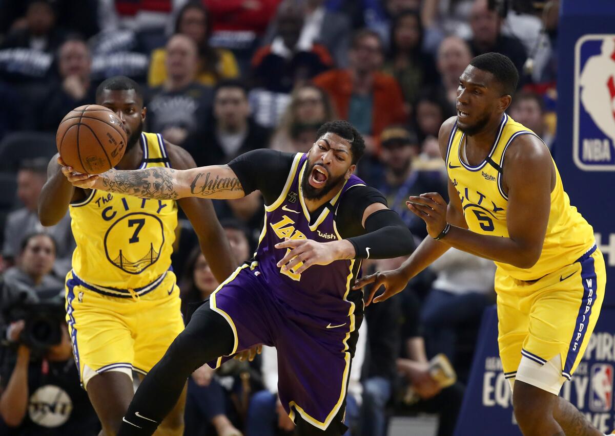 Lakers star Anthony Davis is fouled by Golden State Warriors center Kevon Looney during the Lakers' 116-86 victory Thursday.
