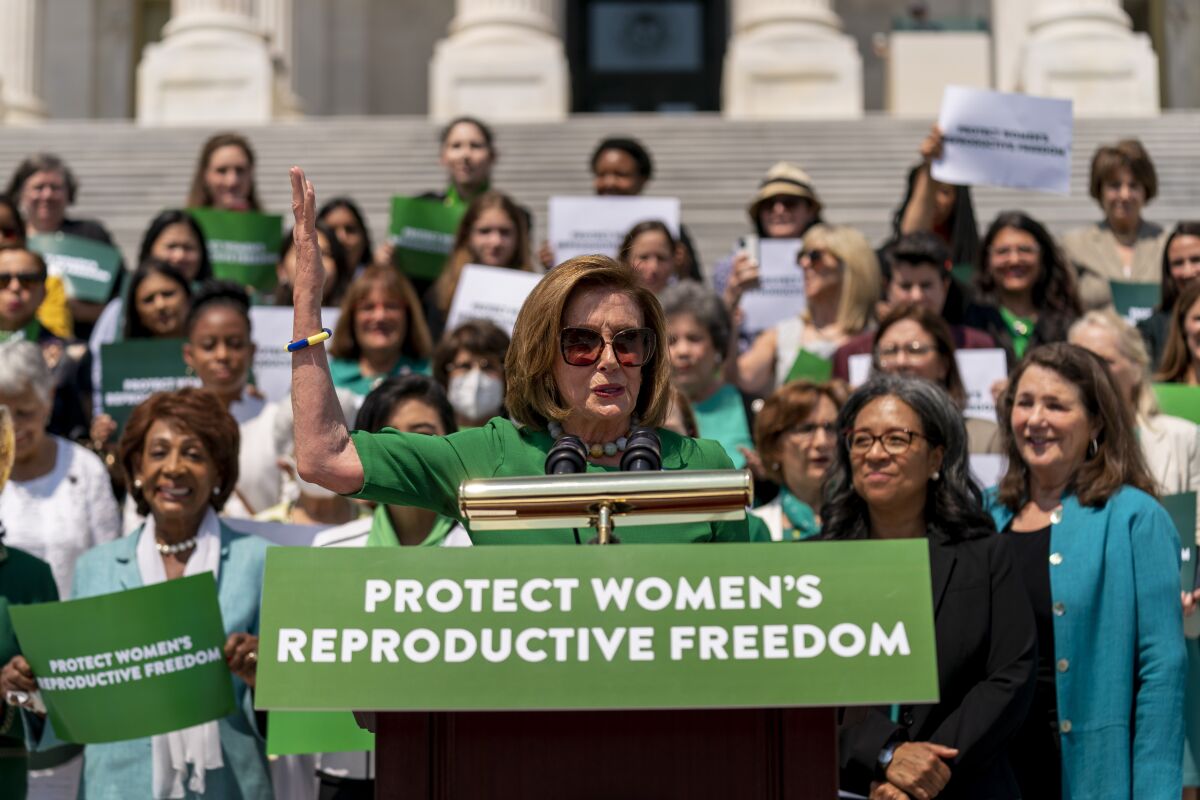 House Speaker Nancy Pelosi, accompanied by female House Democrats, speaks outside the Capitol in Washington.