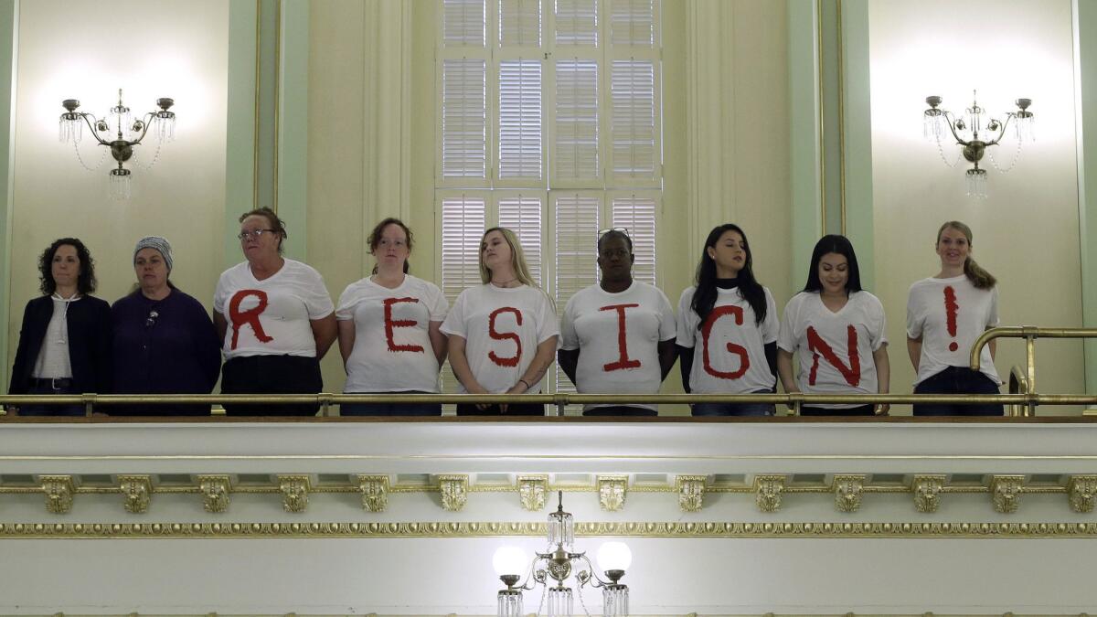 Protesters call on Assemblywoman Cristina Garcia to resign from office while standing in the Assembly gallery on Friday in Sacramento.