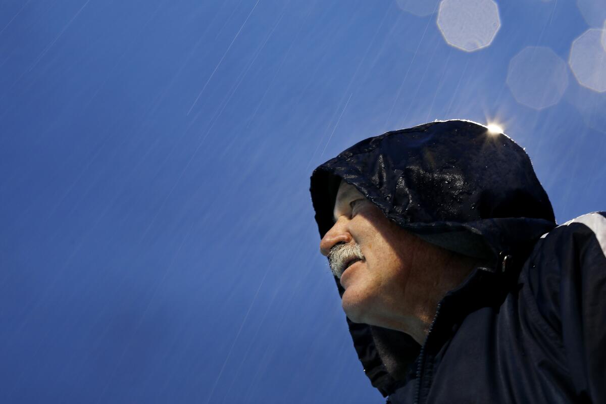 Coach Rick Shipherd leads a workout with swimmers of La Mirada Armada, a year-round swim club, on a cold and rainy day