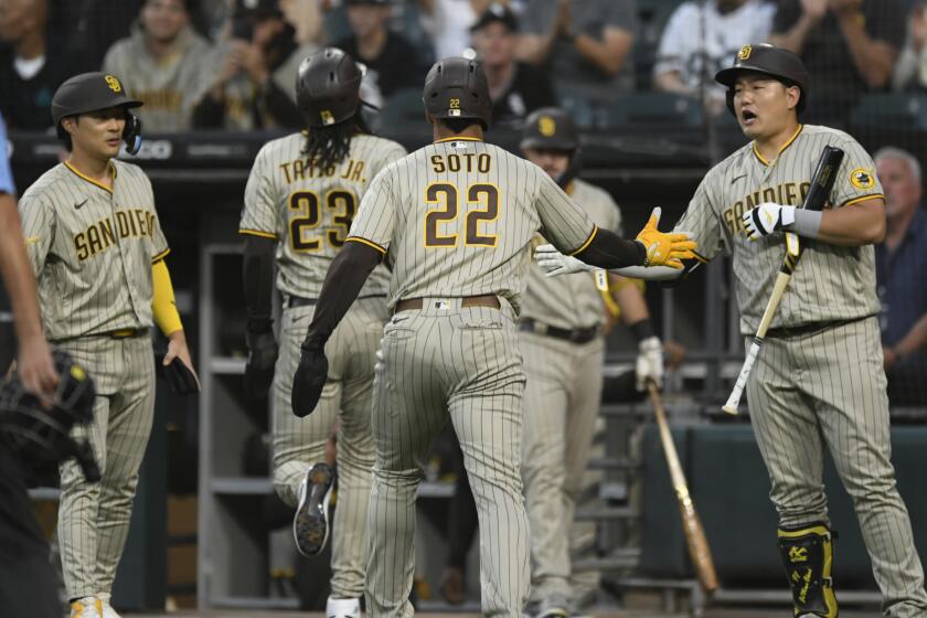San Diego Padres' Juan Soto (22) celebrates with teammate Ji Man Choi right, after scoring on a Jurickson Profar three-run double during the first inning of a baseball game against the Chicago White Sox, Saturday, Sept. 30, 2023, in Chicago. (AP Photo/Paul Beaty)