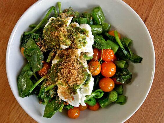 Poached eggs served over fresh market vegetables at Huckleberry.