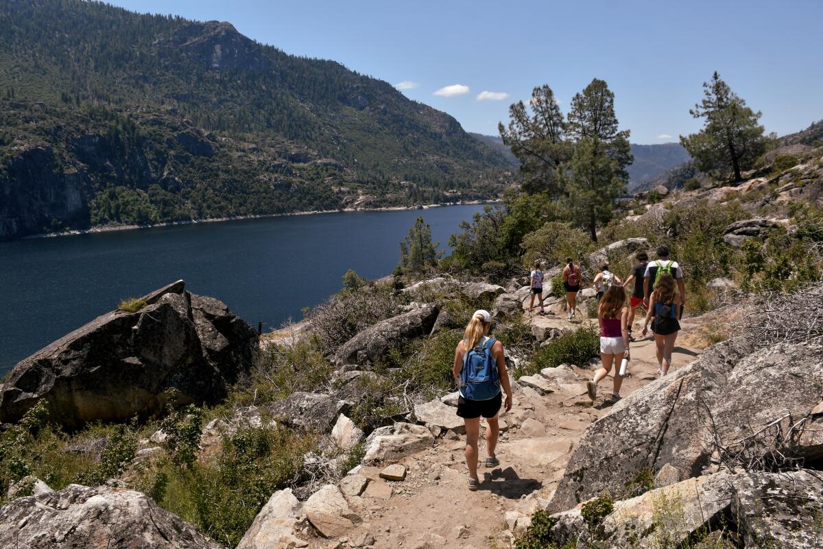 Hikers navigate a trail near the Hetchy Hetchy Reservoir in July 2023. 