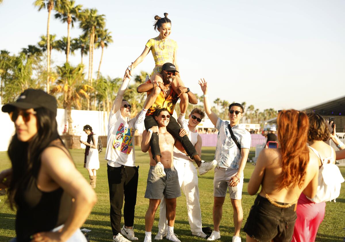 Friends at Coachella standing and sitting on each other's shoulders