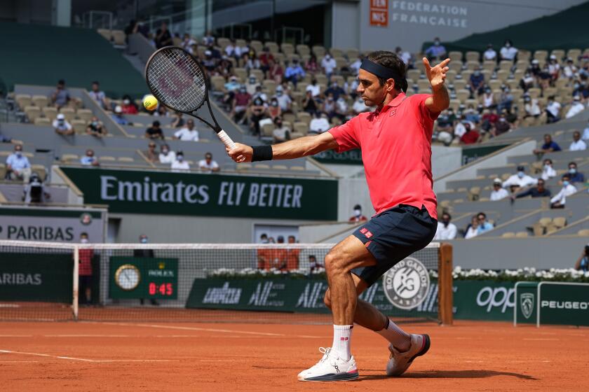 Switzerland's Roger Federer plays a return to Croatia's Marin Cilic during their second round match on day 5.