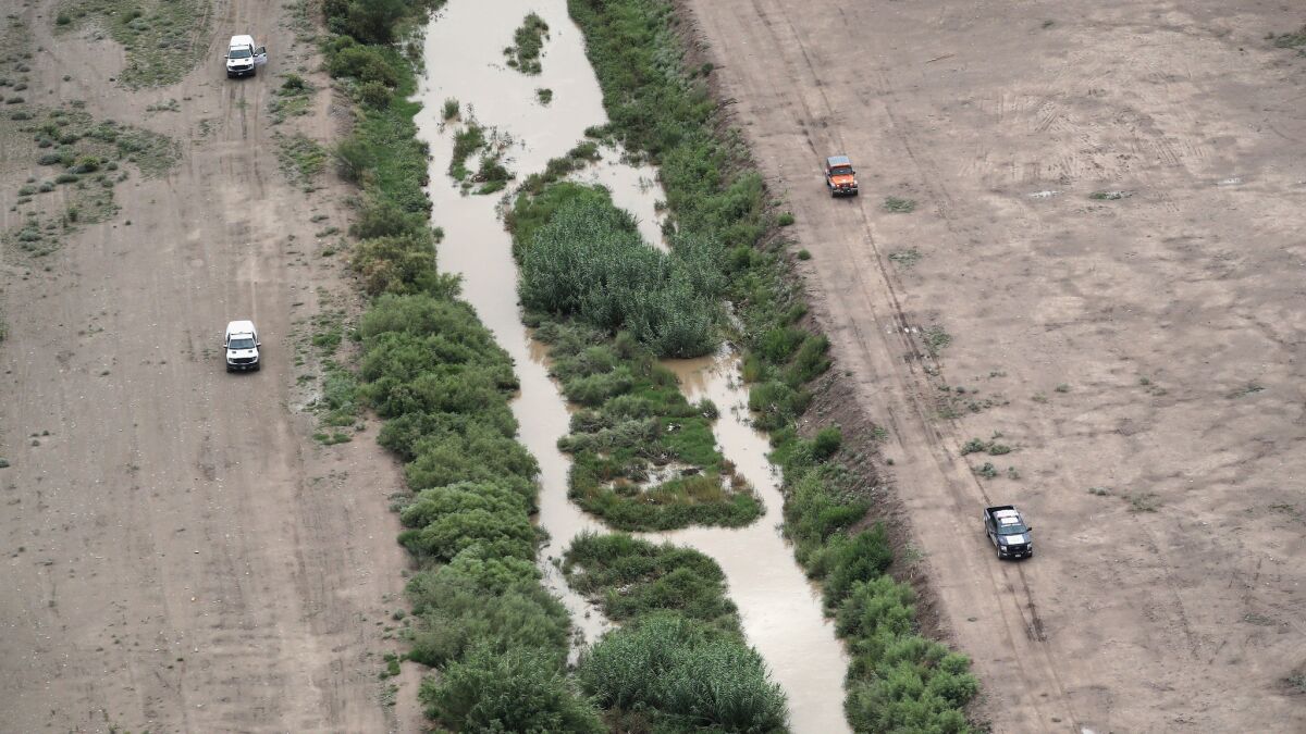 U.S. Border Patrol agents, left, and Mexican immigration agents perform a joint patrol along the Rio Grande at the U.S.-Mexico border in El Paso in August 2017.