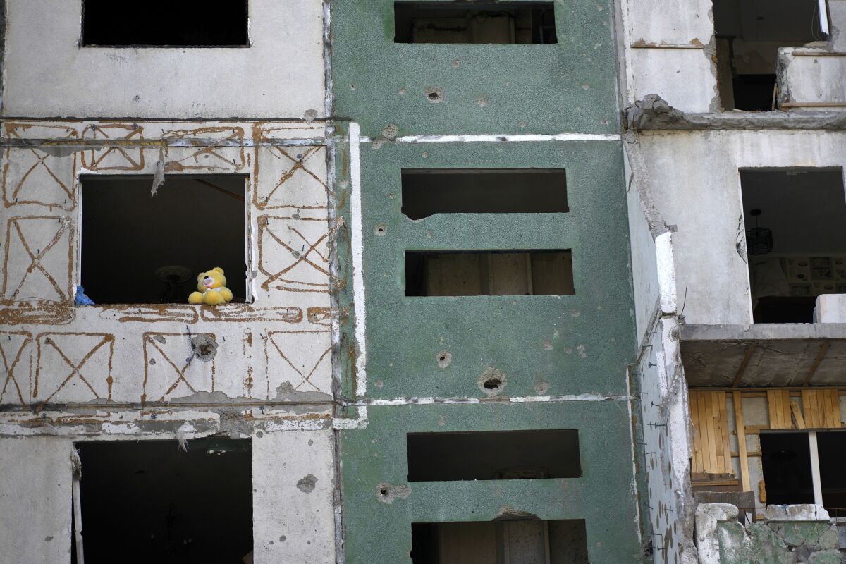 A teddy bear can be seen in the window of a building destroyed by attacks.