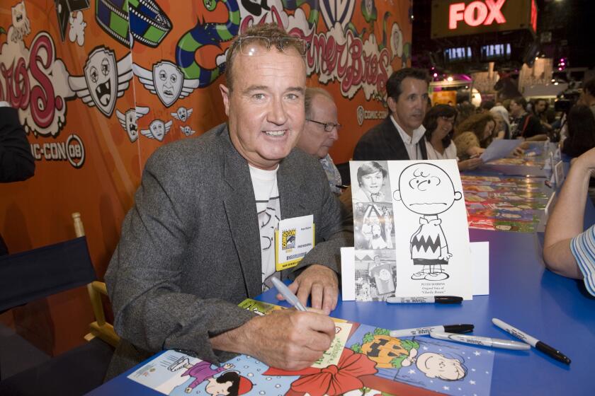 A man sitting at a table signing autographs