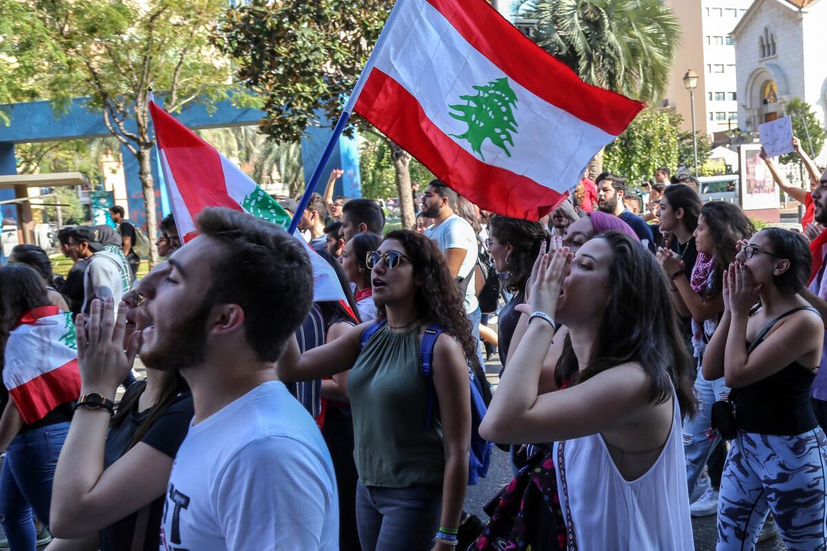 Lebanese students from various universities shout slogans during ongoing anti-government protests as they march from Lebanese University toward Riad Solh Square in Beirut.
