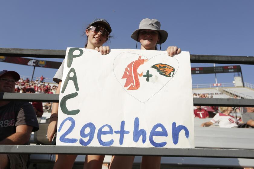 12-year-olds Izzy Aberill, left, and Josie Boyd hold a sign about Washington State and Oregon State being the only two schools left in the Pac-12 after the 2023-2024 academic year after the other schools in the conference announced plans to leave, during the second half of an NCAA college football game between Washington State and Northern Colorado, Saturday, Sept. 16, 2023, in Pullman, Wash. Washington State won 64-21. (AP Photo/Young Kwak)