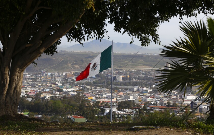 The Mexican flag over Tijuana landscape