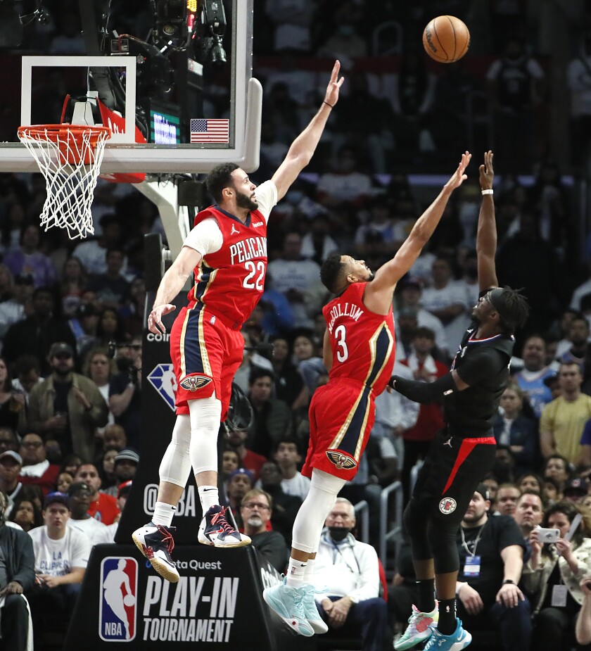 Clippers guard Reggie Jackson lofts a shot over Pelicans forward Larry Nance Jr. (22) and guard CJ McCollum (3).