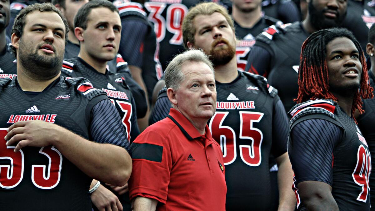 Louisville Coach Bobby Petrino looks on with his players during the team's picture day on Aug. 9. Louisville is the latest team to join the Atlantic Coast Conference.