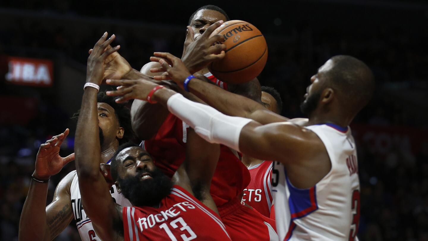 James Harden, center, of the Houston Rockets, battles for the ball during the Clippers 140-132 overtime victory at Staples Center Monday night.