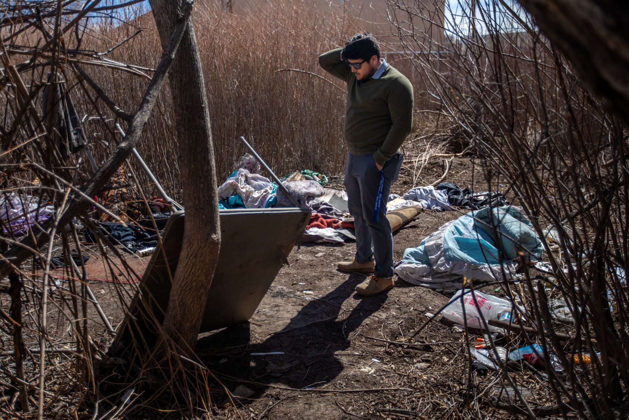 Mężczyzna stoi pośród gruzów w obozie dla bezdomnych 