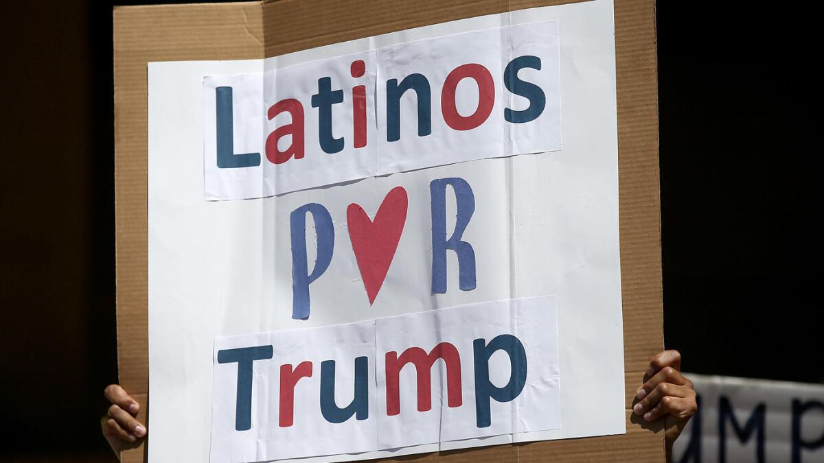 Un hombre sostiene un cartel durante un mitin entre cerca de un centenar de partidarios latinos de Donald Trump, frente al Ayuntamiento de Anaheim, el 28 de agosto de 2016.