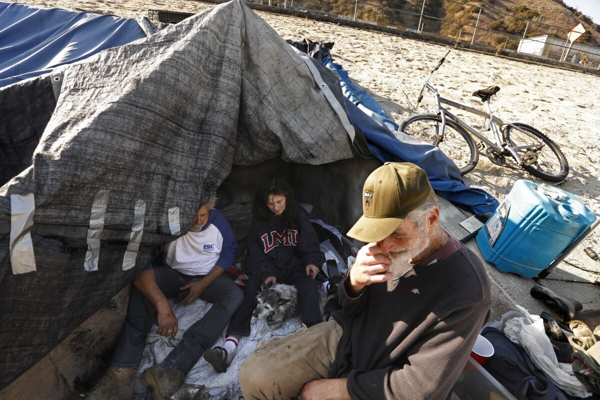 From left, Robin "Country" Boatner, 60; Melissa Millner, 46;and her brother Ed Marchisio, 54, rest near the camp they relocated to above the L.A. River.