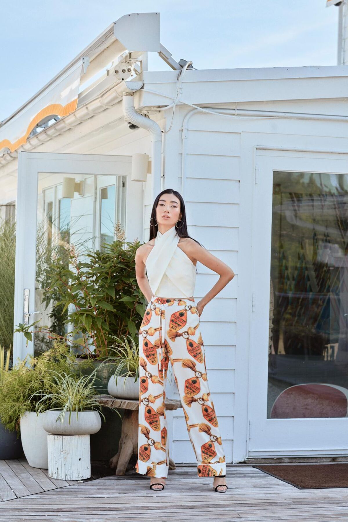 Model wears the Alice wrap top and Tina satin pant in white from Aliétte's resort collection
