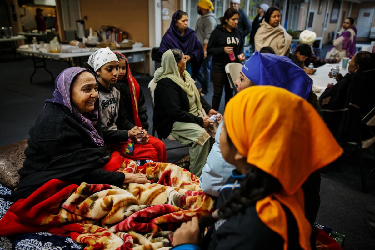 Evacuees and Sikhs chat at Shri Guru Ravidass temple in Rio Linda, Calif., north of Sacramento.