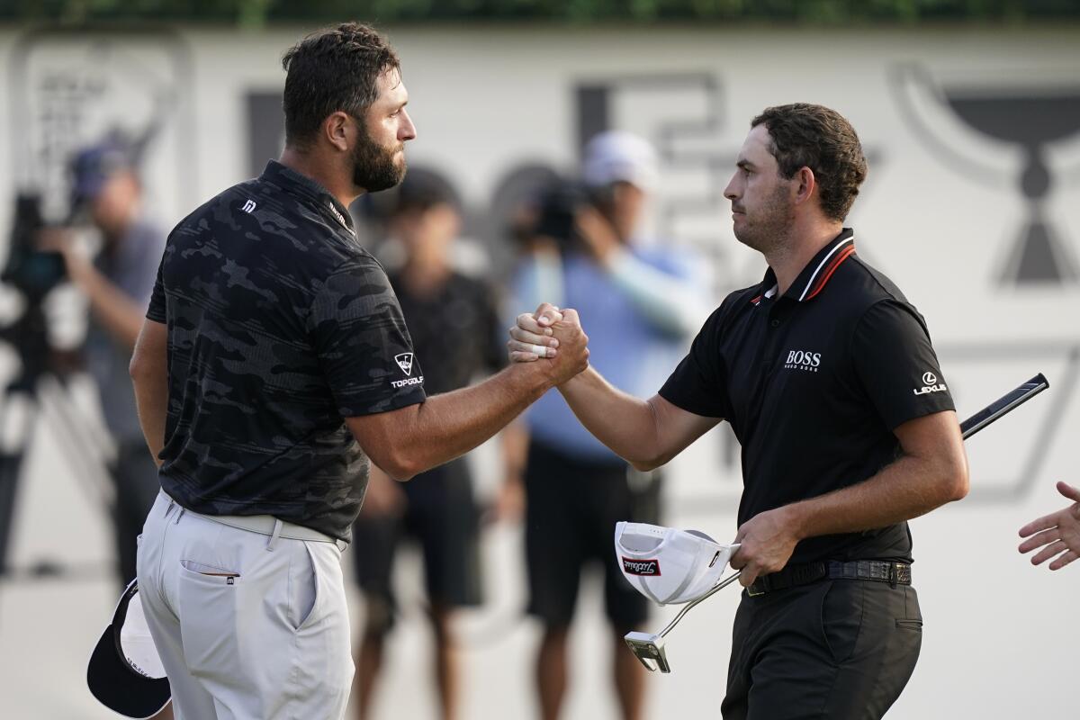 Jon Rahm, left, shakes hands with Patrick Cantlay after the third round of the Tour Championship on Sept. 4, 2021.