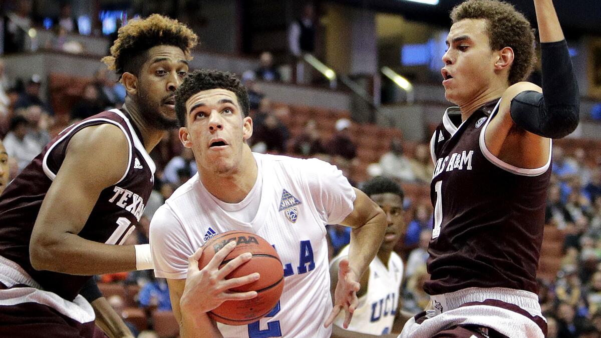 UCLA guard Lonzo Ball drives to the basket between Texas A&M's Tonny Trocha-Morelos, left, and D.J. Hogg during the second half of the championship game in the Wooden Legacy on Sunday.