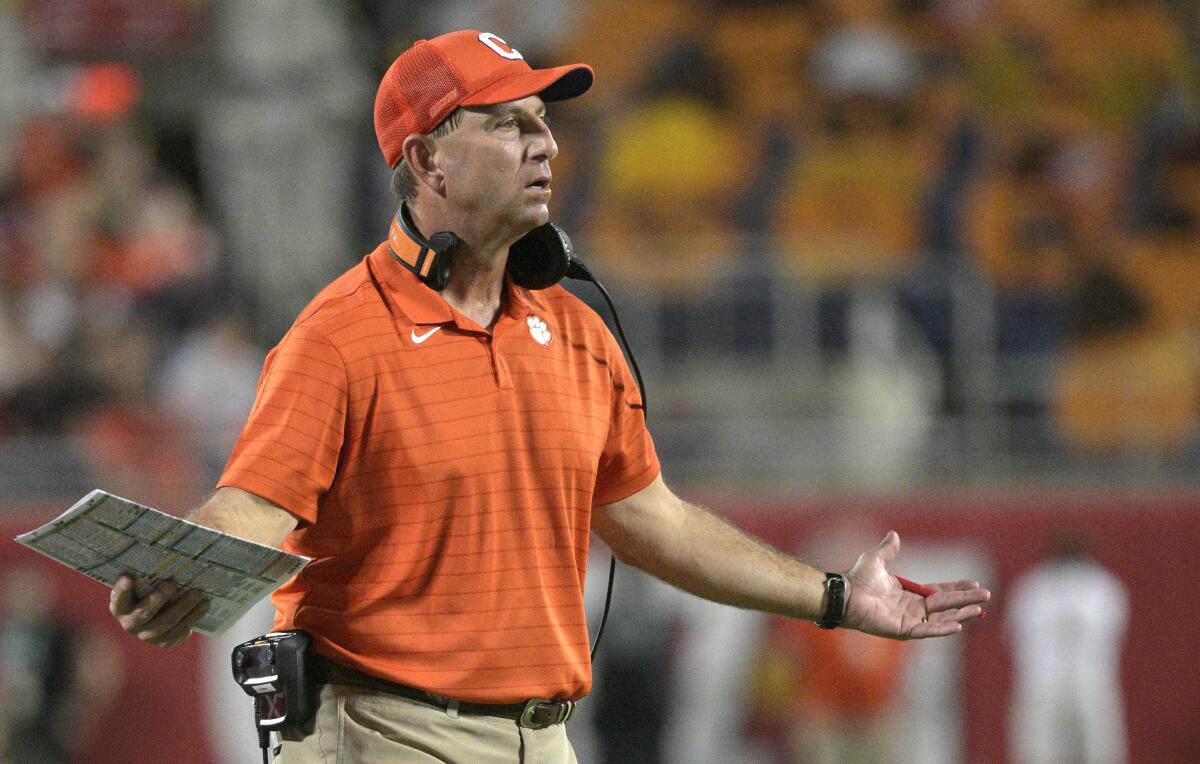 FILE - Clemson head coach Dabo Swinney questions an official after a play during the first half of the Cheez-It Bowl NCAA college football game against Iowa State in Orlando, Fla., Wednesday, Dec. 29, 2021. Clemson had won six straight ACC titles heading into last season, but started 4-3 and fell out of contention for a seventh. The team rebounded, though, to win their last six games — the longest current win streak among Power Five teams — and look to a slimmer, more confident quarterback DJ Uiagalelei to start a new championship run. (AP Photo/Phelan M. Ebenhack, File)