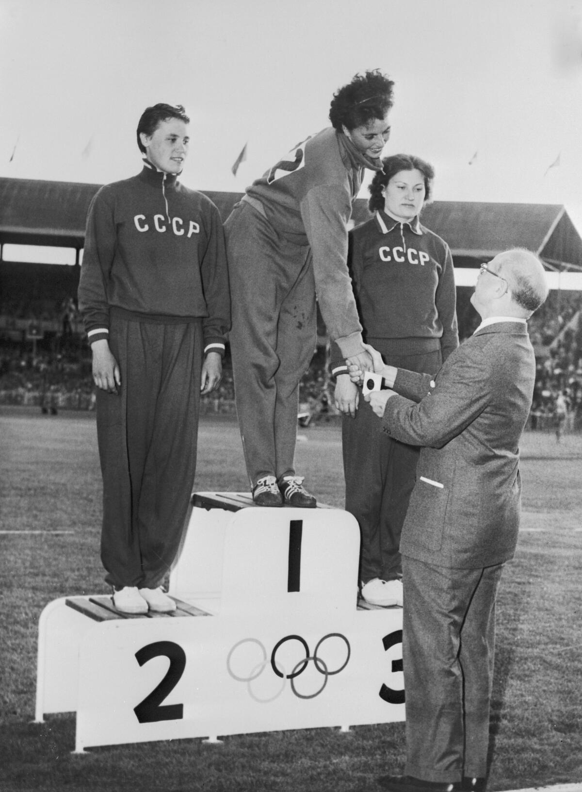 Ольга Фикотова (в центре) из Чехословакии получает золотую медаль в метании диска.