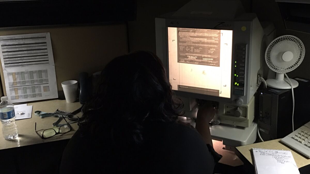 An analyst reviews firearms records on microfilm at the Bureau of Alcohol, Tobacco, Firearms and Explosives' National Tracing Center. (Del Quentin Wilber)