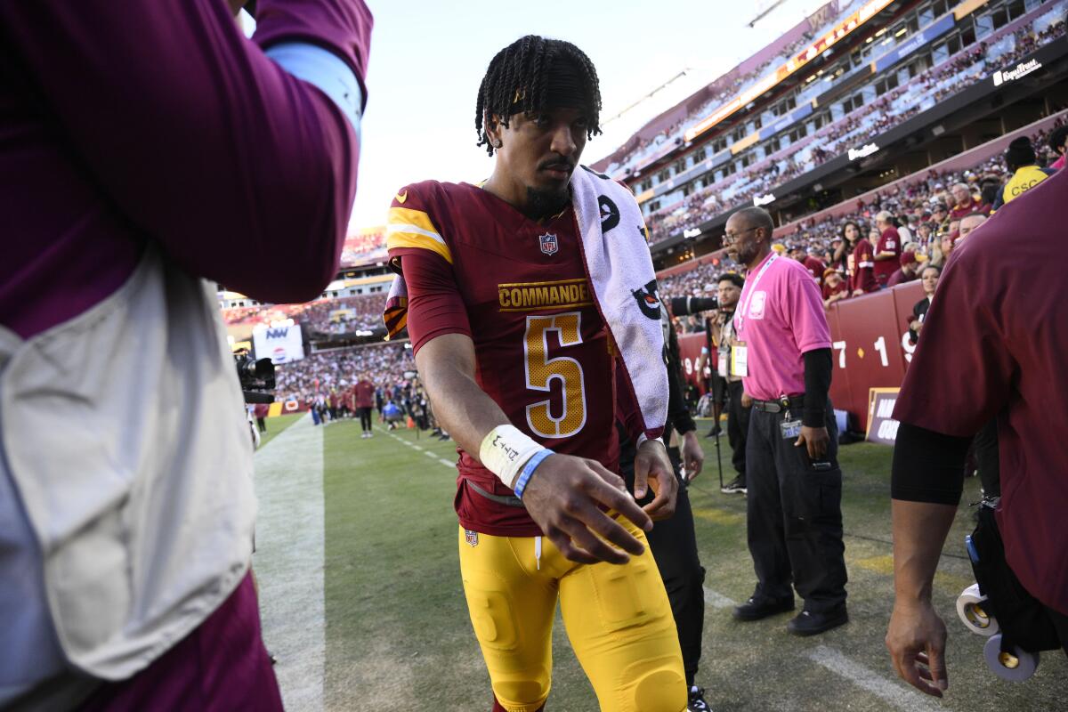 Commanders quarterback Jayden Daniels walks off the field after injuring his ribs against the Panthers.