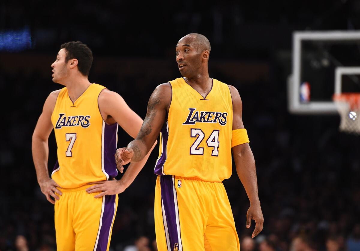 Lakers guard Kobe Bryant (24) and forward Larry Nance Jr. (7) listen to some instructions from the bench during a break against the Raptors in November.