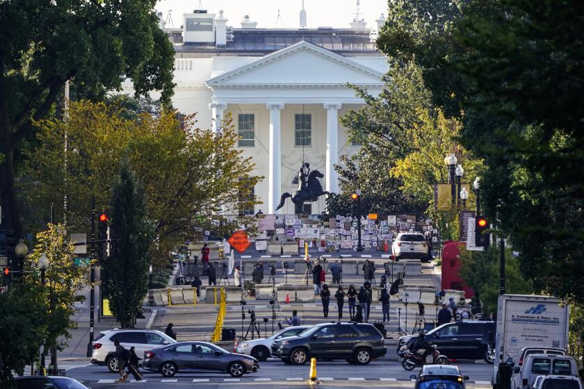 The White House is seen in Washington, early Tuesday, Oct. 6, 2020, the morning after President Donald Trump returned from the hospital where he was treated for COVID-19. Traffic moves along K Street NW as TV crews set up in Black Lives Matter Plaza. (AP Photo/J. Scott Applewhite)