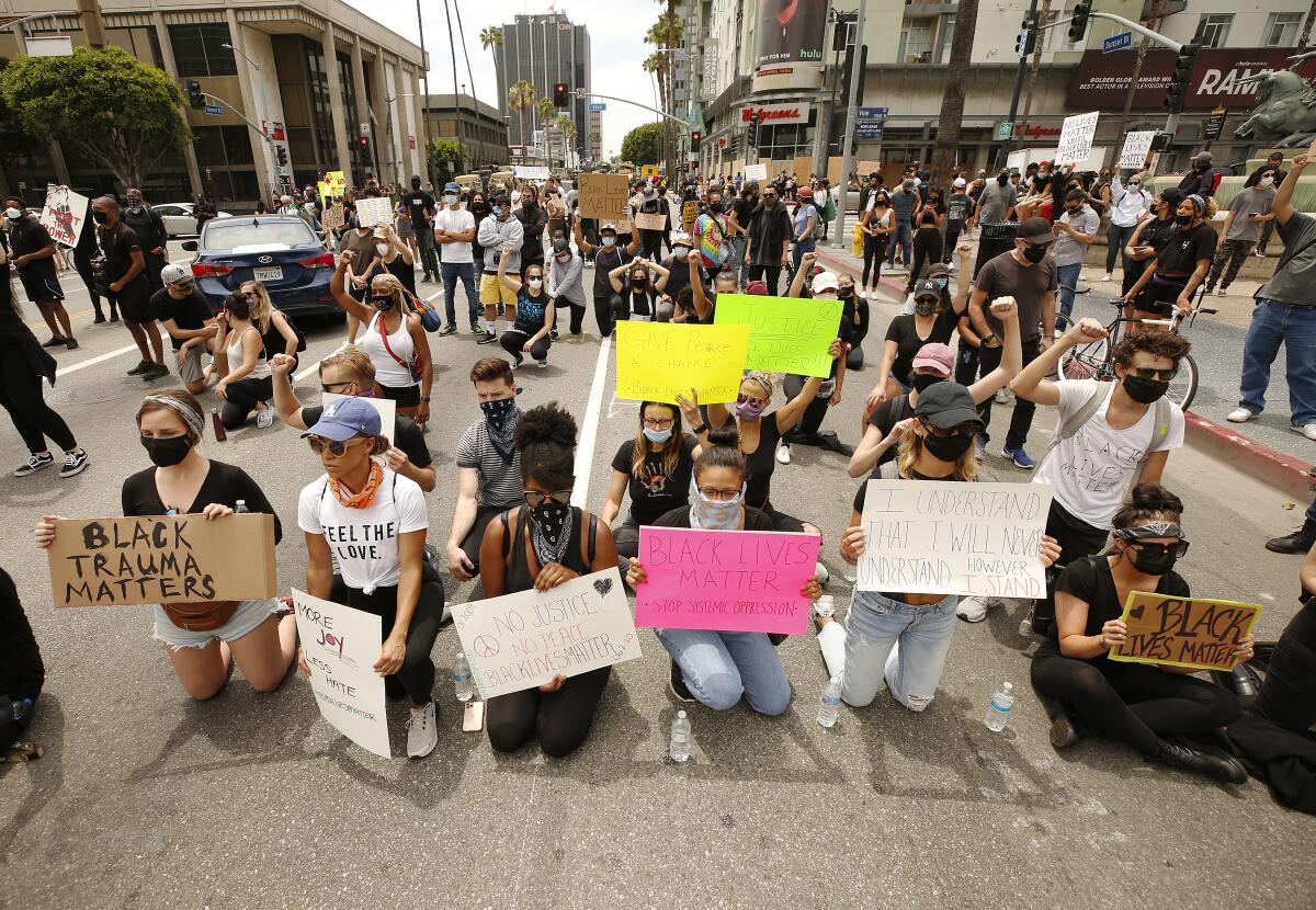 Protesters take a knee in front of LAPD officers at Vine Street in Hollywood.