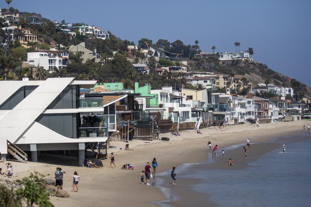 A thin strip of beach with houses on the sand