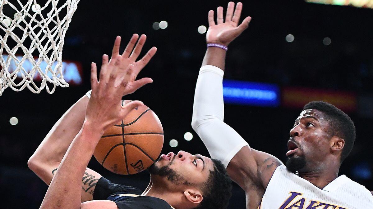 New Orleans Pelicans' Anthony Davis, left, grabs a rebound in front of Lakers' David Nwaba in the fourth quarter Sunday at Staples Center.