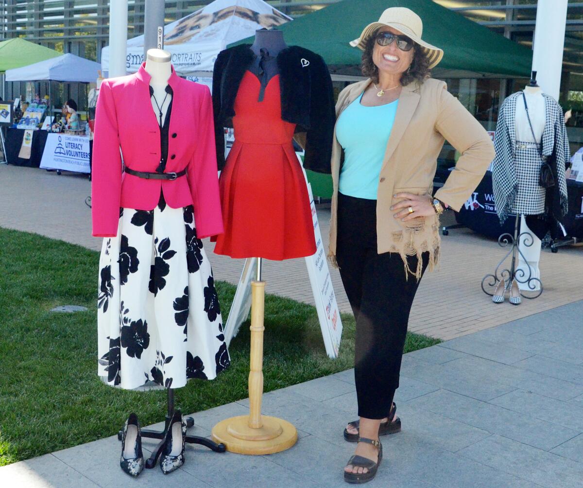 Working Wardrobes CEO Bonni Pomush displays clothing items provided by the organization at its Spring Festival.