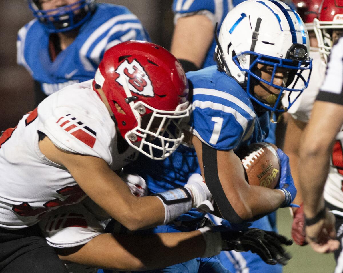 Burroughs’ Isaac Glover is stopped by Burroughs’ Adrian Leon during Friday's homecoming game at Memorial Field. (Photo by Miguel Vasconcellos)