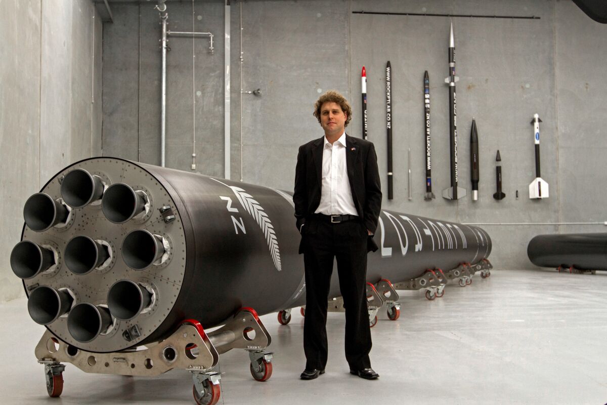 Peter Beck, Rocket Lab's chief executive, with the company's Electron rocket. (Geoff Dale / Rocket Lab)