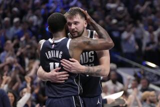 The Dallas Mavericks' Kyrie Irving and Luka Doncic embrace while celebrating the team's win during a playoff series