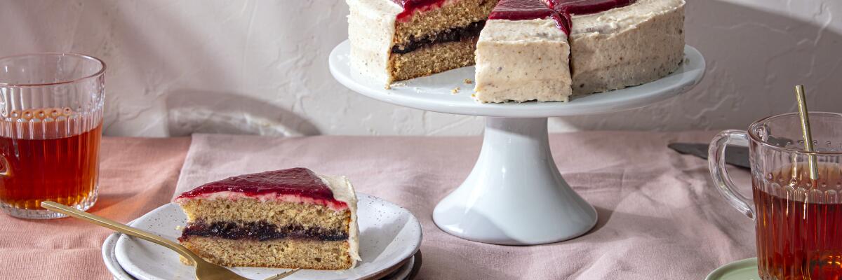 Brown Butter & Fig Cake with Raspberry Ripple has two layers of cake with piece cut out on a stack of dessert plates.