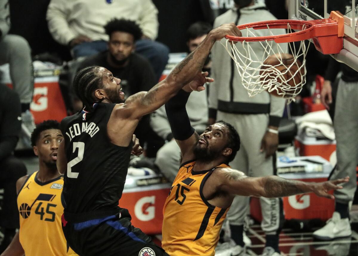 Clippers forward Kawhi Leonard slam dunks over Jazz center Derrick Favors during Game 4 of their playoff series.