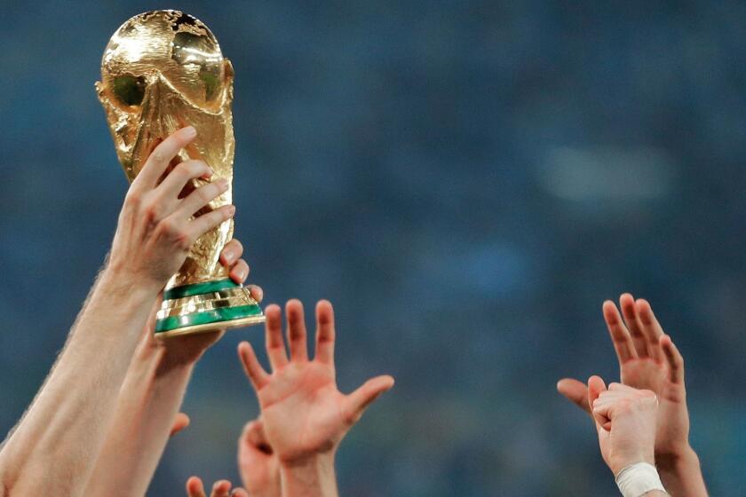 FILE - In this Sunday, July 13, 2014 file photo, German players reach out to touch the trophy after the World Cup final soccer match between Germany and Argentina at the Maracana Stadium in Rio de Janeiro, Brazil. Morocco will bid to host the 2026 World Cup, giving a joint bid from North America some competition. The Morocco Football Federation announced its intention to bid on Friday, Aug. 11, 2017 the deadline for countries to express their interest. (AP Photo/Matthias Schrader, File)