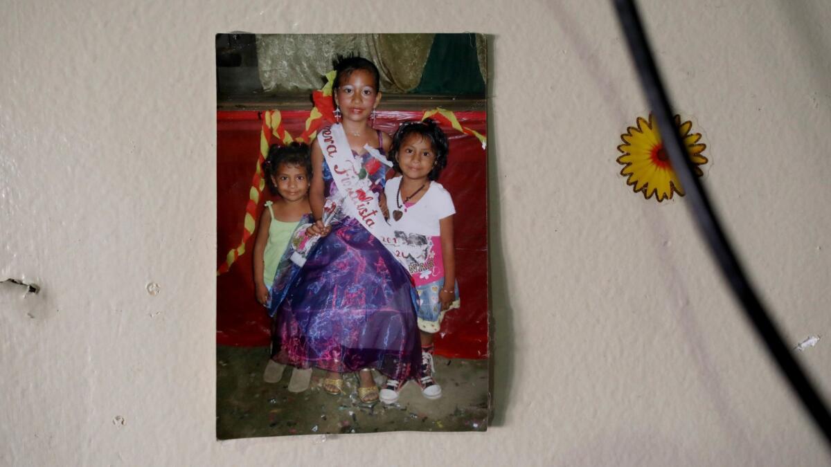 A photo of Rubilia Sanchez's daughters Maquisha Perez, left, Ellie and Dashley, taken when they lived in Guatemala, hangs at their home in Los Angeles.