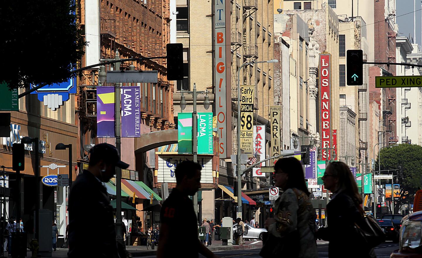 Pedestrians cross Broadway in L.A.'s historic commercial core. Businesses catering primarily to Latino immigrants have kept the sidewalks active as most buildings fell empty above the first floor.