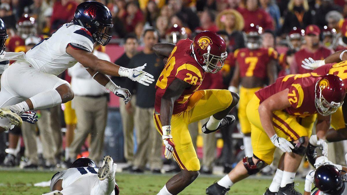 USC running back Aca'Cedric Ware (28) heads for a first down in the first half against Arizona at the Coliseum. Using the NCAA's Graduation Success Rate, 73% of USC football players graduated.