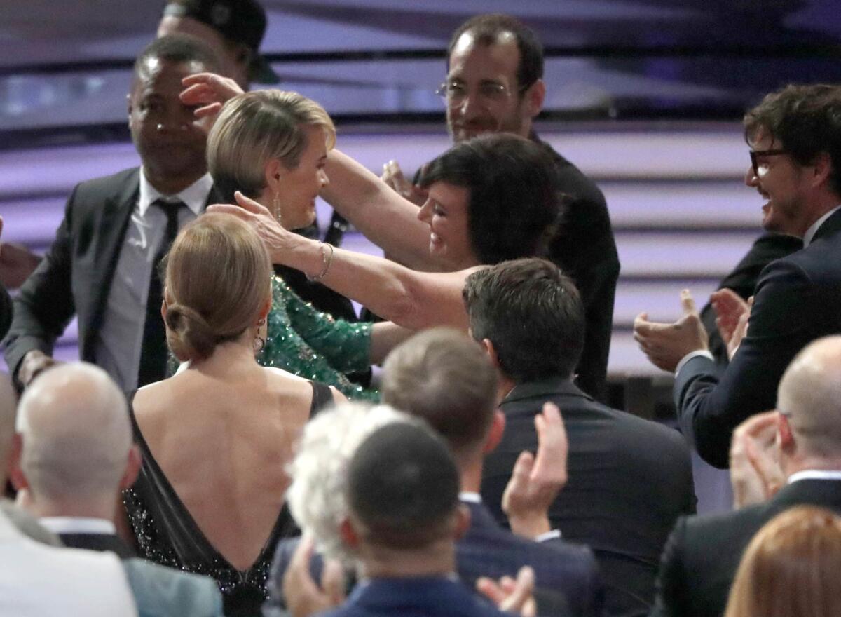 Sarah Paulson, center, hugs Marcia Clark after winning the Emmy for lead actress in a limited series or movie at the Emmy Awards at the Microsoft Theater in Los Angeles.