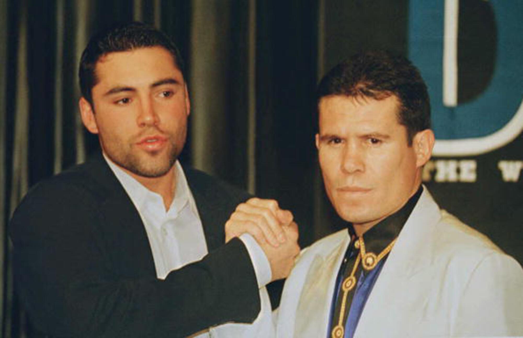 Julio César Chávez, right, clasps hands with WBO lightweight champion Oscar De La Hoya
