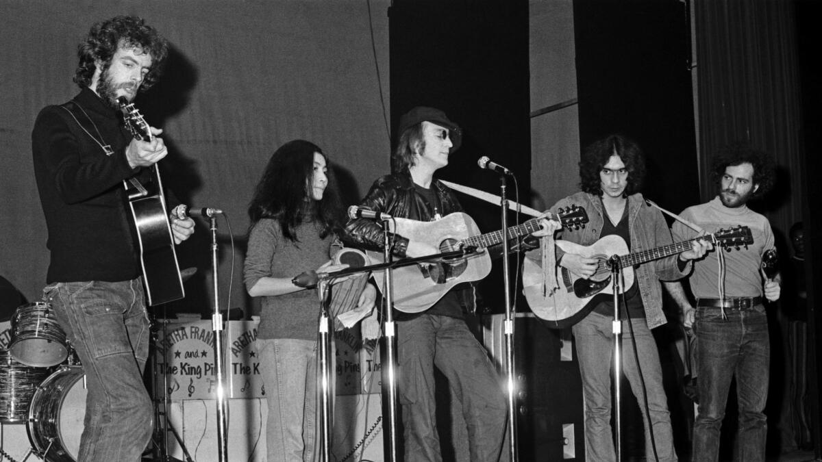 John Lennon and Yoko with Jerry Rubin(far right) playing percussion onstage at the Apollo Theater