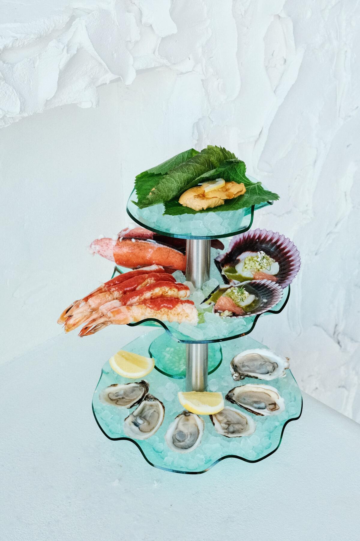 A three-tier seafood tower against a textured white stucco wall at Cento Raw Bar in West Adams.